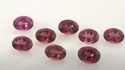 a group of polished and faceted red garnet gemstones