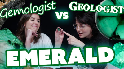 A gemologist and geologist observe a polished and faceted emerald gemstone.