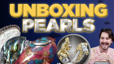 A man gleefully observes different pearl specimens