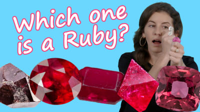 A gemologist inspects ruby specimens with a 10x magnification loupe.