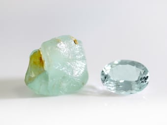 rough aquamarine specimen and oval shaped aquamarine gemstone