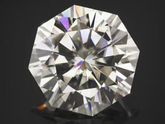 A polished and faceted moissanite gemstone displaying optical doubling.