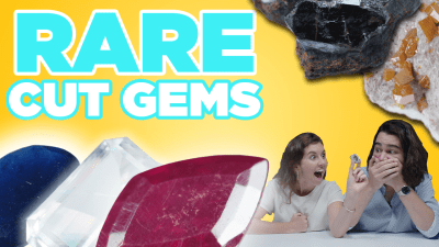 Two gemologists observe rare faceted gemstones.